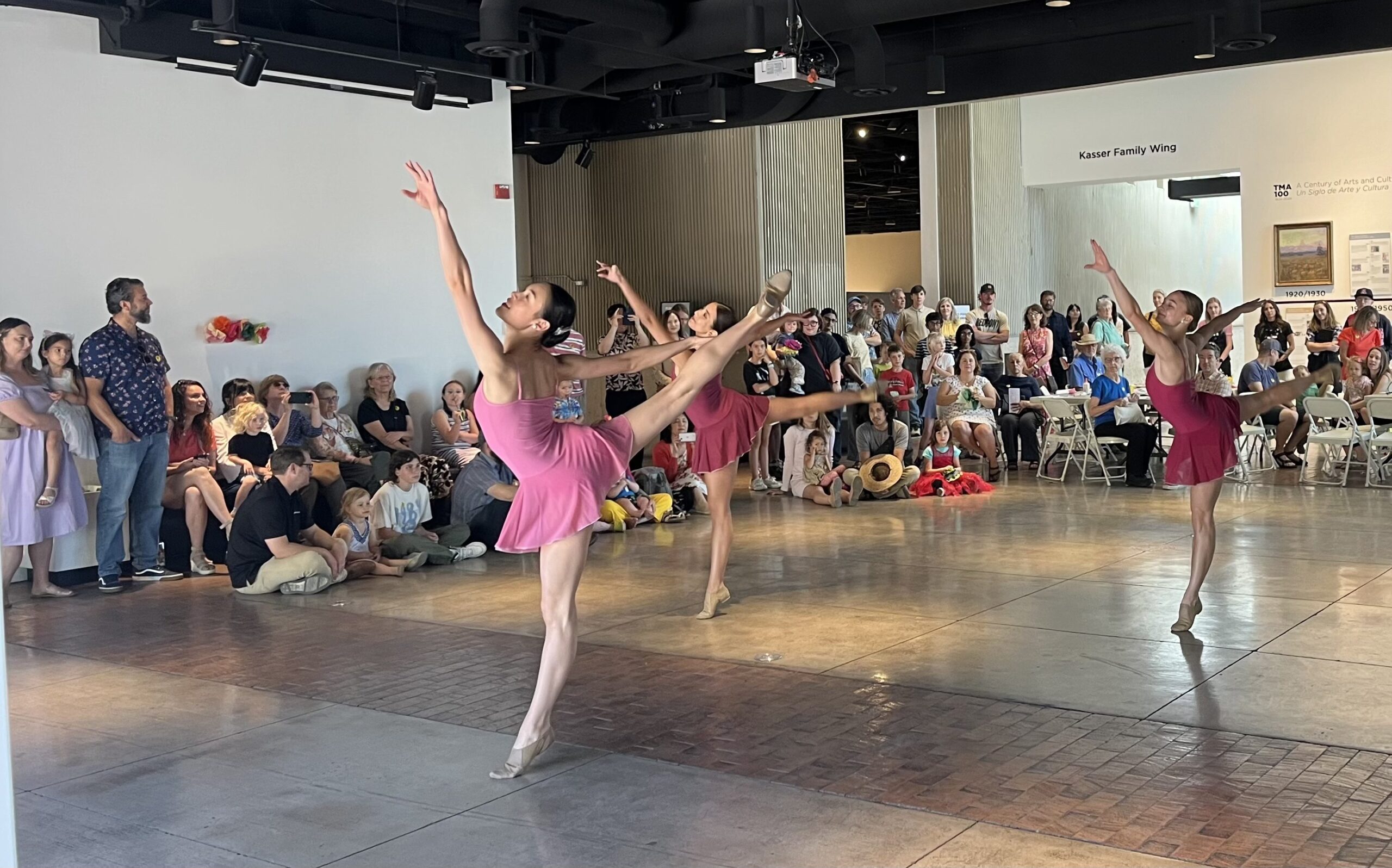 Dancers performing to a standing audience.